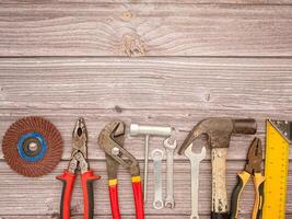 Construction tools, a hammer, screwdriver, screws, and pliers on a wooden table photo