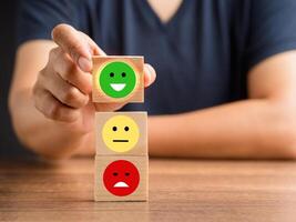 Good feedback rating and positive customer review. The client handpicked the happy face smile icon on the wooden cube over the table photo