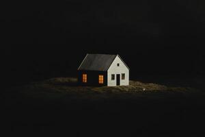 A small house is lit up with a light inside photo