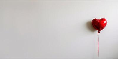 Red heart-shaped balloon against a white background for Valentine's Day. photo