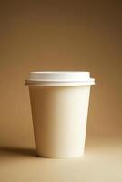 A white coffee cup with a white lid sits on a tan background photo