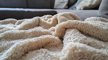 A fuzzy white blanket is spread across a couch photo