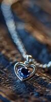 Heart-shaped pendant necklace with a single sapphire photo