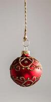 A red ornament hanging from a rope photo