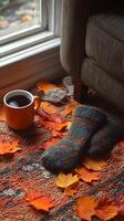 A mug of coffee sits on a rug next to a pair of knit mittens photo