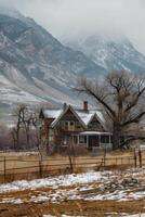 Rustic Abandoned House in Snowy Mountain Landscape with Bare Trees and Cloudy Sky in Winter photo