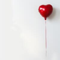 Red heart-shaped balloon against a white background for Valentine's Day. photo
