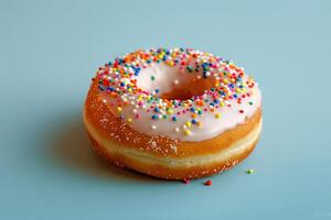 Delicious Glazed Donut with Colorful Sprinkles on a Light Blue Background photo