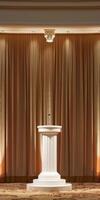 A white podium with a microphone stands before rich brown curtains photo