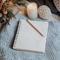 Cozy Still Life with Blank Notebook, Candle, and Knitted Textures photo