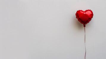 Red heart-shaped balloon against a white background for Valentine's Day. photo