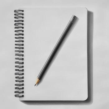 A pencil is on top of a spiral notebook photo