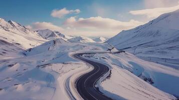Drone shot of a road trip through a snowy mountain pass photo