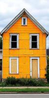 A yellow house with boarded up windows photo
