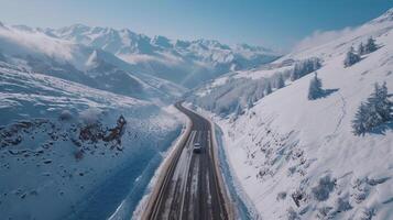 Drone shot of a road trip through a snowy mountain pass photo