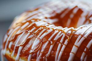 Close-Up of a Delicious Glazed Doughnut with Caramel and White Icing Drizzles photo