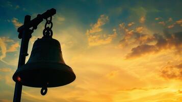 Silhouette of a church bell ringing out the call to worship and praise photo