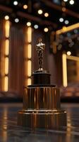 Golden Award Trophy on Stage with Dramatic Lighting in Elegant Theater Setting photo