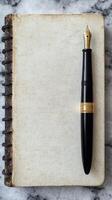 Clásico cuaderno con elegante fuente bolígrafo en mármol superficie para escritura y creatividad inspiración foto