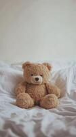 Cozy Teddy Bear on Soft White Bedding in Minimalist Bedroom Setting for Comfort and Warmth photo