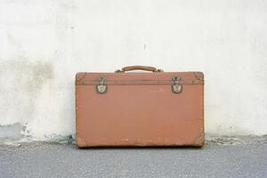 Vintage Leather Suitcase Against Weathered Wall Evoking Nostalgia and Adventure photo