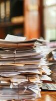 Stack of Documents and Papers on Office Desk with Blurred Background in Warm Lighting photo