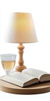 Cozy Reading Nook with Open Book, Glass of Wine, and Warm Lamp Light on Wooden Table photo