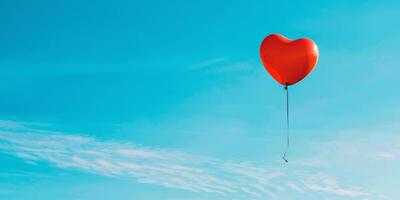 A red heart-shaped balloon floating in a crystal-clear blue sky photo