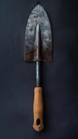 Vintage Garden Trowel with Wooden Handle on Dark Background photo