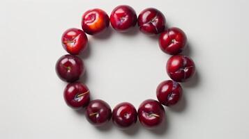 Minimalistic composition of ripe plums arranged in a radial pattern photo