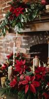 A fireplace mantle is decorated with red poinsettias and gold candles photo