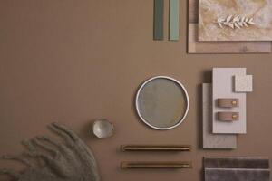 Creative flat lay composition of interior designer moodboard with textile and paint samples, panels and tiles. Beige, brown and green color palette. Copy space. Template. photo
