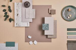 Creative flat lay composition of interior designer moodboard with textile and paint samples, panels and cement tiles. Beige, grey and green color palette. Copy space. Template. photo