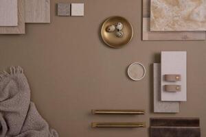 Creative flat lay composition with textile and paint samples, panels and tiles. Stylish interior designer moodboard. Golden and dark beige color palette. Copy space. Template. photo