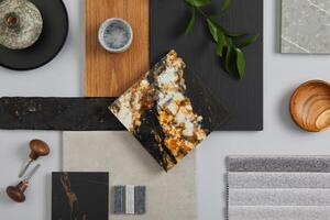 Elegant architect moodboard flat lay composition in light grey, black and brown color palette with textile and paint samples, wooden panels and marble tile. Top view. Copy space. Template. photo