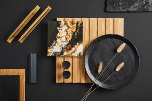 Stylish flat lay comosition of creative architect moodboard with samples of textile, paint, wooden lamella panel and marble tile. Golden, black and beige color palette. Copy space. Template. photo
