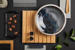 Elegant flat lay composition of interior designer moodboard with textile and paint samples, lamella panel and tiles. Black and grey color palette. Copy space. Template. photo