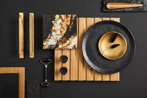 Stylish flat lay comosition of creative architect moodboard with samples of textile, paint, wooden lamella panel and marble tile. Golden, black and beige color palette. Copy space. Template. photo