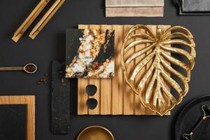 Stylish flat lay comosition of creative architect moodboard with samples of textile, paint, wooden lamella panel and marble tile. Golden, black and beige color palette. Copy space. Template. photo