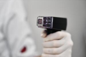 A healthcare worker holds a medical instrument in a sterile environment photo
