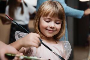 Girl joyfully painting with brushes during an art class in her studio photo