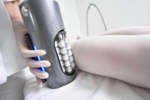 Advanced massage therapy device in use on a clients leg during a session photo