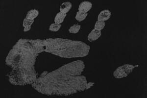 a print of a man's hand on a black sheet of paper photo