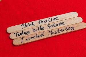 Positive thoughts for increasing self-esteem on wooden posts on red background photo