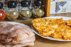 the process of cooking chicken chops with already fried chops in the background photo