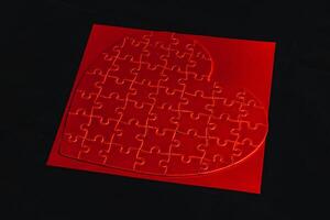 Conceptual photo of puzzle, heart shape for Valentine's Day on black background