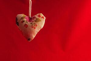 Textile heart with flowers on a red background photo