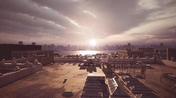 Golden sunset over city skyline from rooftop view during evening hours video