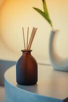 aromatherapy and home perfume concept - aroma reed diffuser on wooden shelf photo