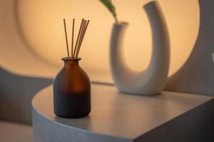 aromatherapy and home perfume concept - aroma reed diffuser on wooden shelf photo
